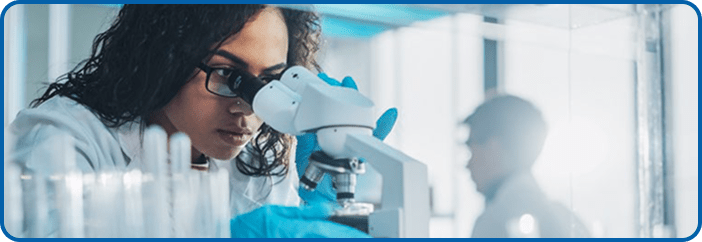 woman looks into a microscope
