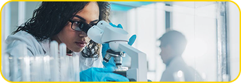 woman looks into a microscope